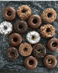 a bunch of doughnuts that are on top of a piece of wax paper