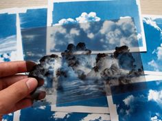 a person holding up some pictures with clouds in the sky behind them on blue and white paper