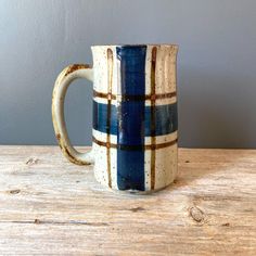 a blue and white mug sitting on top of a wooden table