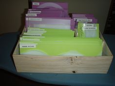 a wooden box filled with files and folders on top of a blue cloth covered table