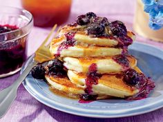 a stack of pancakes with blueberries and syrup