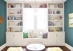 a living room filled with lots of bookshelves next to a white window sill