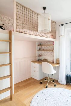 a bedroom with a loft bed, desk and chair in the corner next to a window