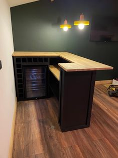 an empty room with wood flooring and cabinets