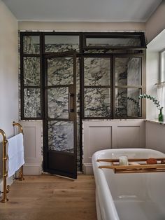 a bath room with a tub and a towel rack on the wall next to it