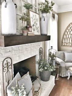 a living room filled with furniture and a fire place covered in potted plantes