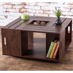 a coffee table made out of wooden crates with books on it and a plant in the center