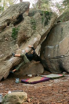 a man climbing up the side of a large rock