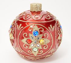 a red glass ornament with gold trimmings and colorful jeweled decorations