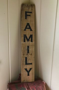 a wooden sign that says family on it next to two old suitcases and a box