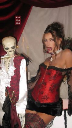 a woman in a red and black corset next to a skeleton