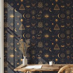 a table with two cups on it in front of a wallpapered background that has an all seeing eye pattern