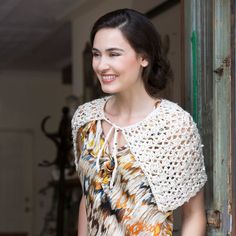 a woman standing in front of a door with her hand on her hip and smiling at the camera