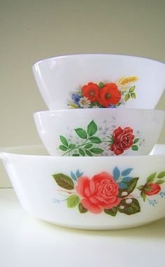 three white bowls with red flowers on them