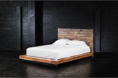 a bed that is made with wood and white sheets