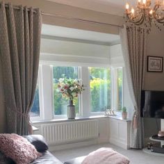 a living room filled with furniture and a flat screen tv on top of a stand