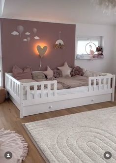 a white day bed sitting on top of a hard wood floor next to a window