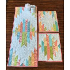 two quilted placemats with cups on them