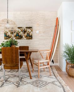 a dining room table with chairs and a rug on the floor