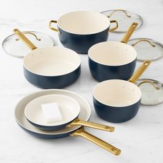 blue pots and pans with gold handles on a marble table