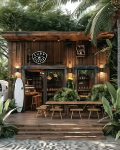 a surf shop with palm trees and chairs on the deck, surrounded by greenery