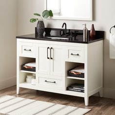 a white bathroom vanity with black counter top