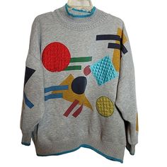 a gray sweater with colorful patches on it