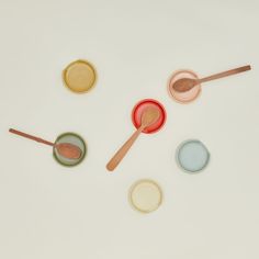 three spoons and two bowls with different colored lids