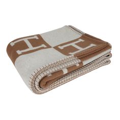 two blankets folded on top of each other with brown and white squares in the middle