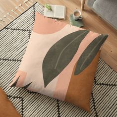 a pink and green pillow sitting on top of a rug