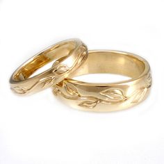 two gold wedding rings sitting on top of each other