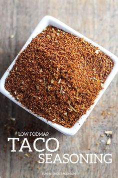 a white bowl filled with spices on top of a wooden table