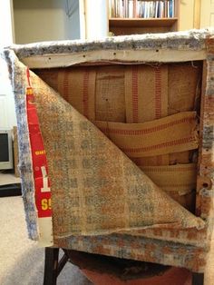 an old chair that has been turned into a bookcase with some fabric on it