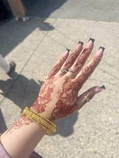 a woman's hand with henna tattoos on it