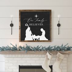 a christmas sign hanging on the wall above a fireplace with stockings and stockings in front of it