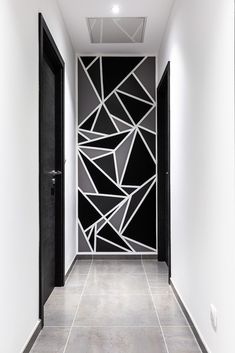 the hallway is decorated with black and white geometric wallpaper, along with an open door that leads to another room