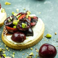 two small pastries with fruit on them and pistachios around the edges