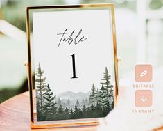 a table number card with trees and mountains in the background