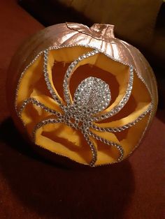 an orange pumpkin decorated with silver and diamonds