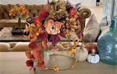 an arrangement of flowers and pumpkins on a table