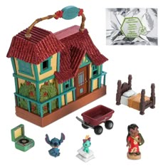 the toy house is set up with figurines and other items in front of it