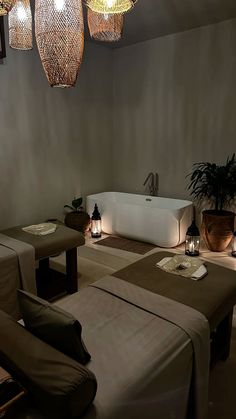 a spa room with two massage tables and three lights hanging from the ceiling above them