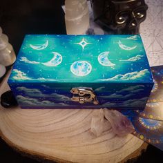 a blue box sitting on top of a wooden table covered in stars and moon paintings