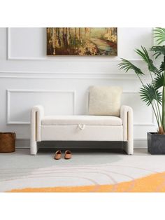 a white couch sitting next to a potted plant on top of a carpeted floor