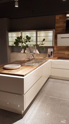 a modern kitchen with white cabinets and wood counter tops is pictured in this image from the front view