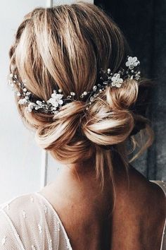 a woman with blonde hair wearing a flowered headpiece in front of a mirror