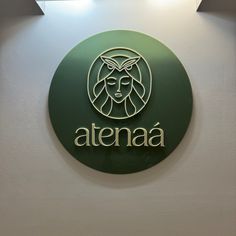 the sign on the wall says atena with a woman's face and leaves