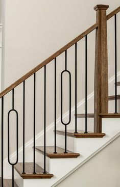 a set of stairs with metal handrails and wood balconies in a home