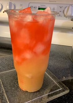 an orange and yellow drink sitting on top of a counter next to a dryer