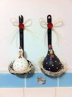 two black and white birds sitting on top of each other in a nest next to a tile wall